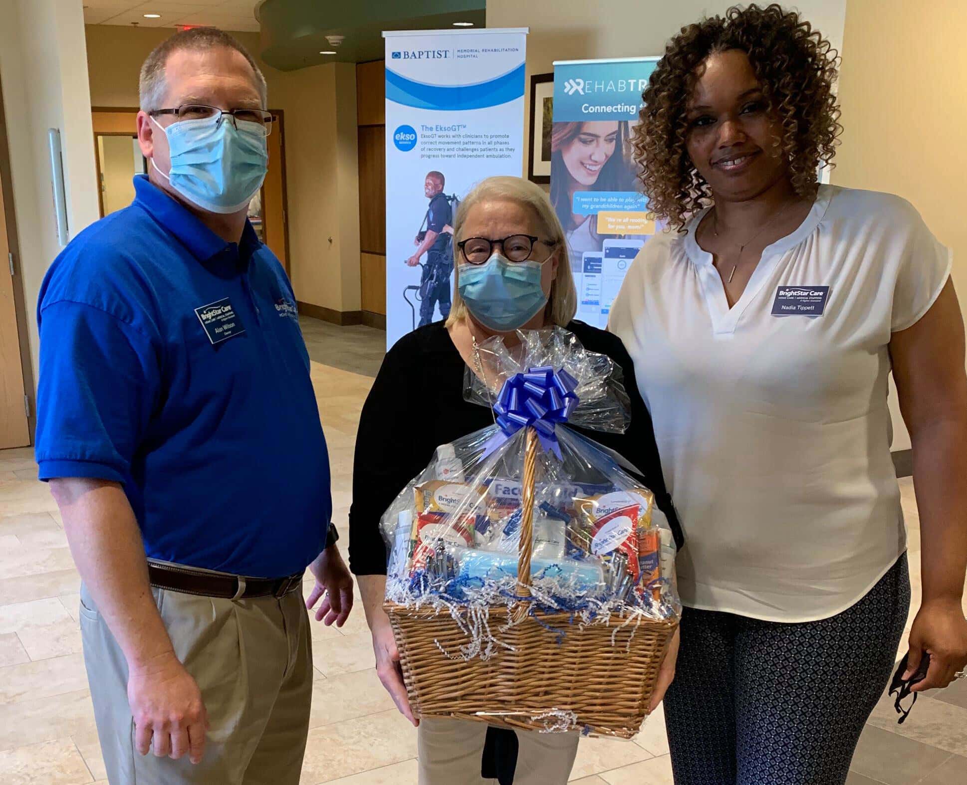 lady with basket of goods in between company staff