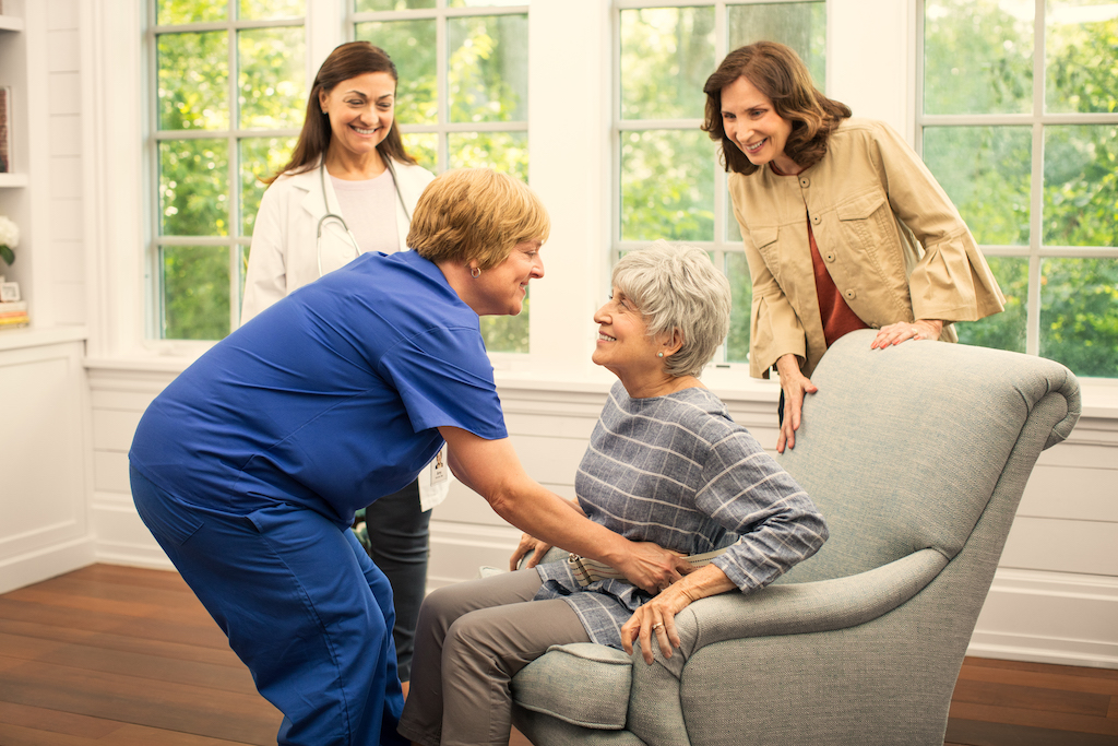 A BrightStar Care nurse helps a client and her family.