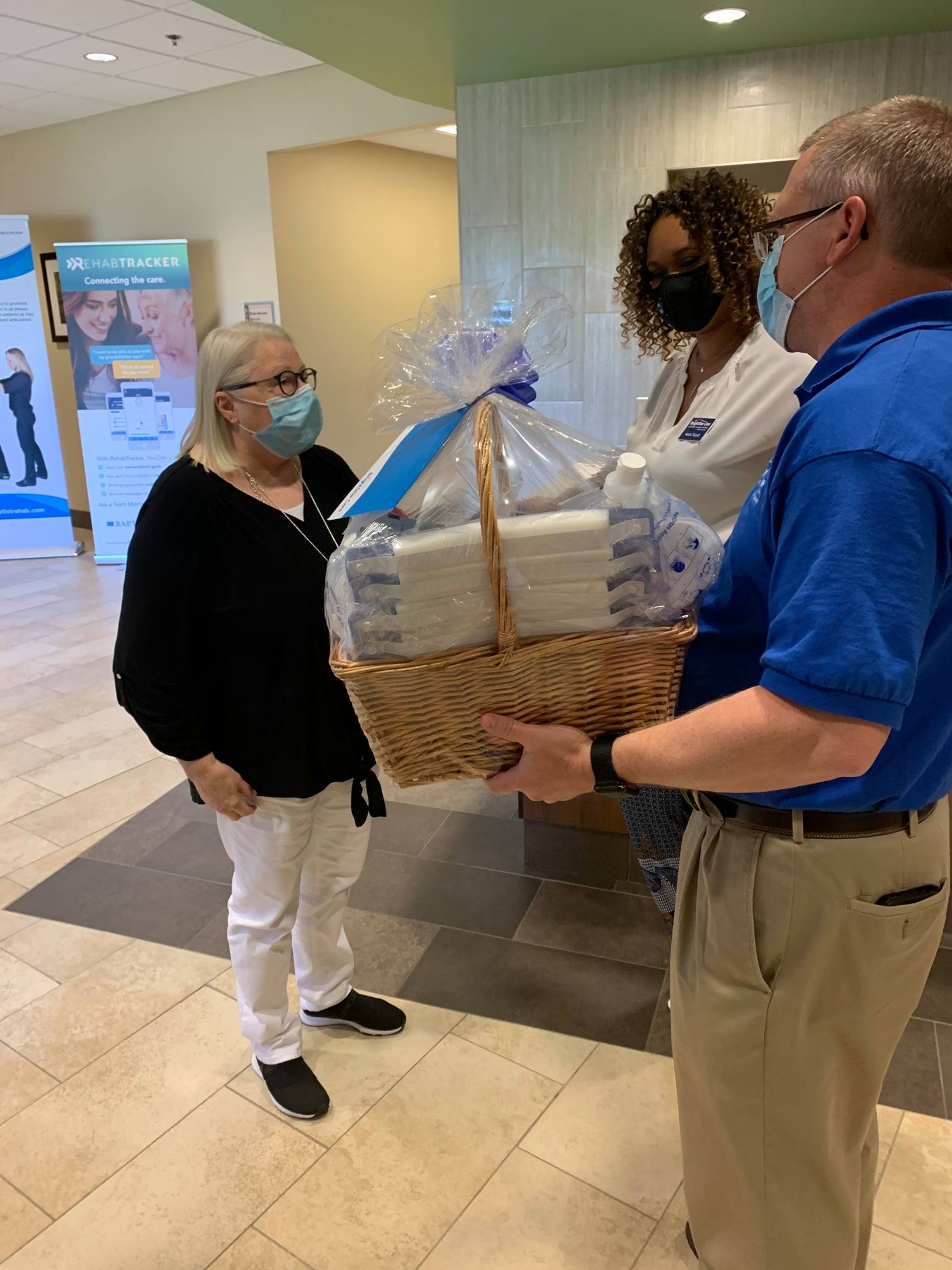 lady receiving gift basket from company staff