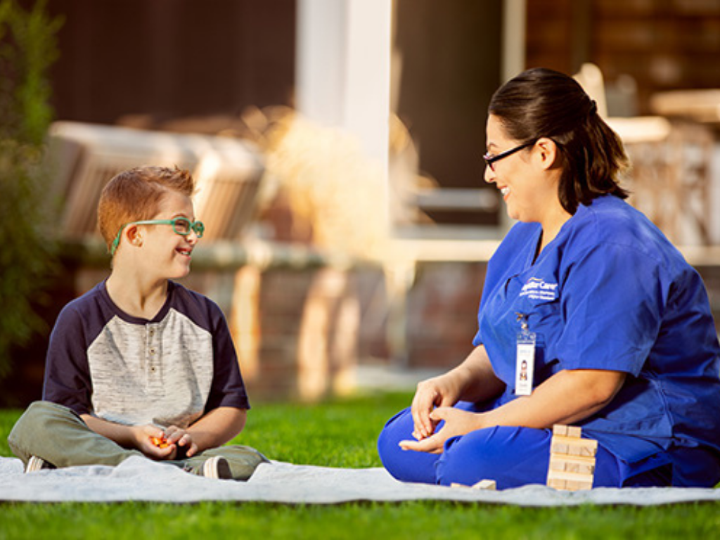 BrightStar Nurse and Patient sitting in the grass