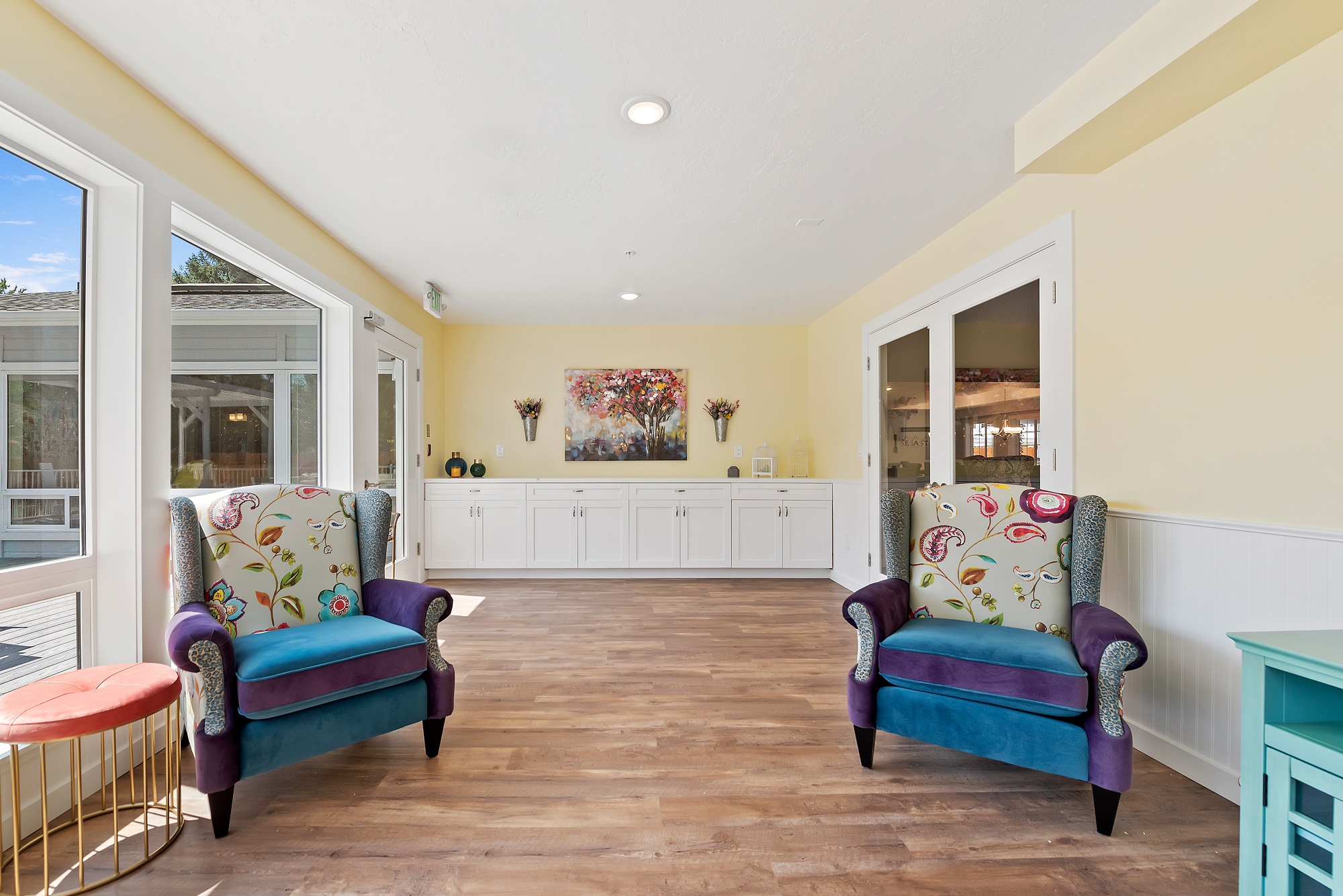 A photo of the interior of a BrightStar Care Homes franchise, with two arm chairs and a row of cupboards behind them. 